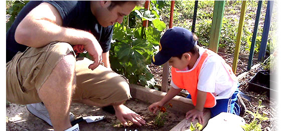 Medical student teaching a member of the Latino Gardening & Nutrition Program how to plant a vegetable garden. This program was organized through a partnership between the Allied Wellness Center and the Office of Community Service Programs at the University of Wisconsin School of Medicine and Public Health. Website: http://www.med.wisc.edu/education/md/communityservice/main/148
