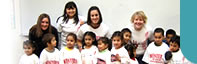 Western Oregon University (WOU) Students with Latino children enrolled in a preschool program called Lecturas en Familia (Family Readings). This is a program developed by the Farmworker Housing Development Corporation at Colonia Amistad in Independence, OR.  On this day, WOU students taught a lesson plan that included painting WOU shirts donated by the WOU bookstore.